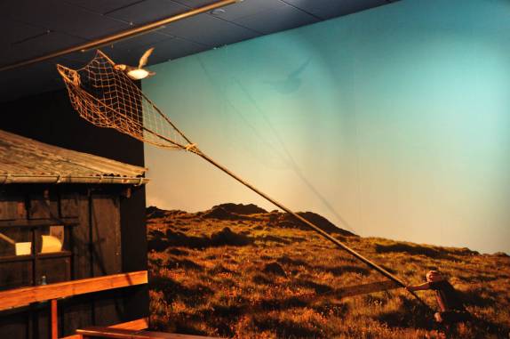 Painel no museu de Vestmannaeyjum mostra como se fazia a captura do puffin na ilha de Heimaey, no sul da Islândia